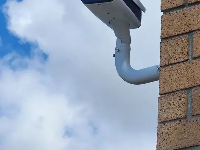 Bullet camera on a brick plaza wall