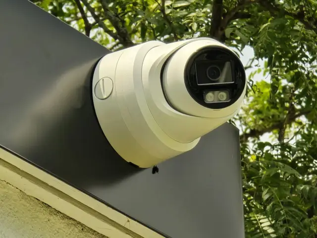Turret camera on a roofline under trees